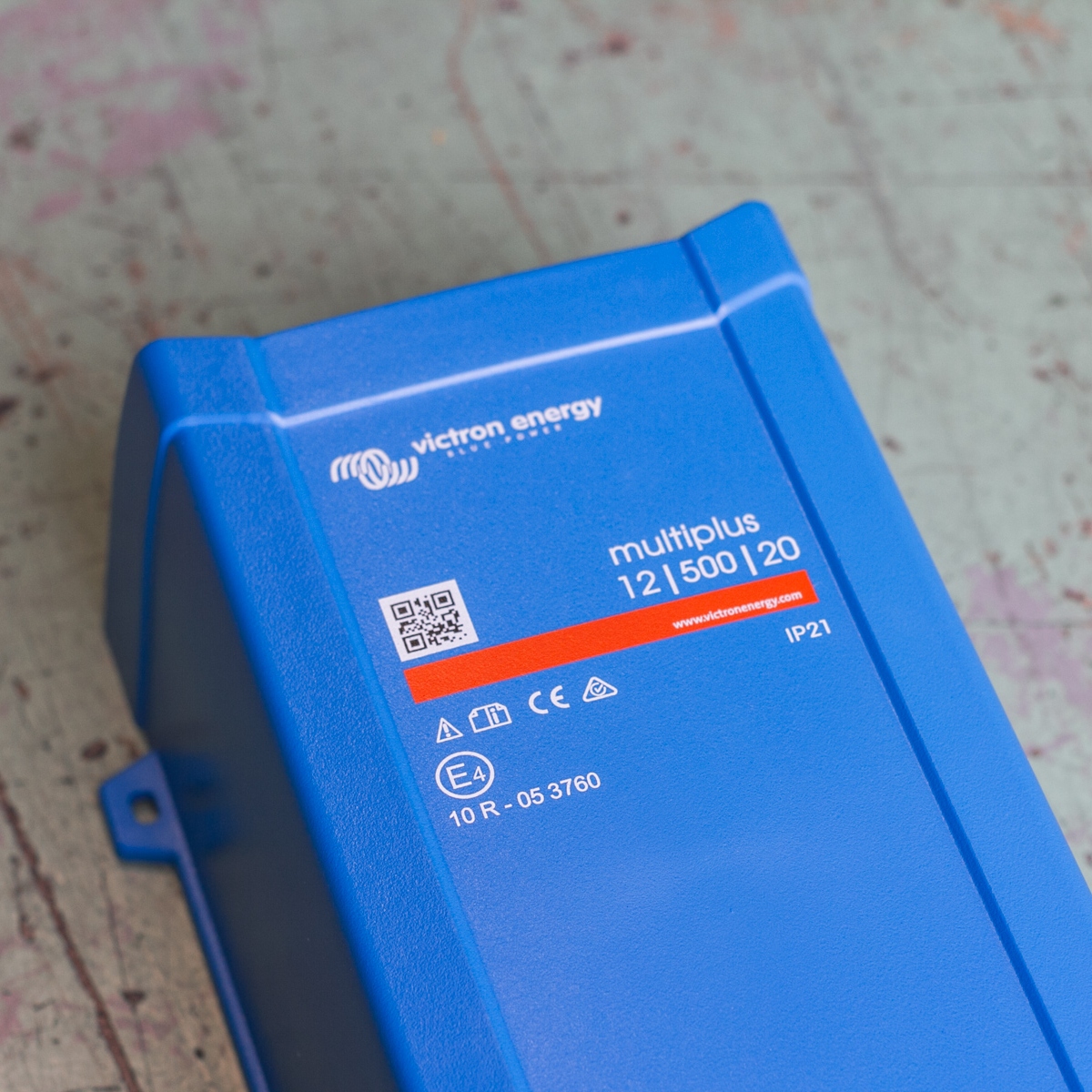 Close-up of a blue Victron MultiPlus 500VA 12V Inverter/Charger on a worn surface.