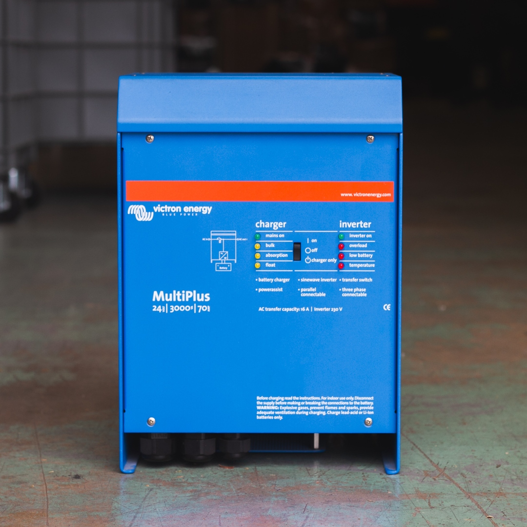 A Victron MultiPlus 24V 3000VA Inverter/Charger in blue, standing on a concrete floor indoors.