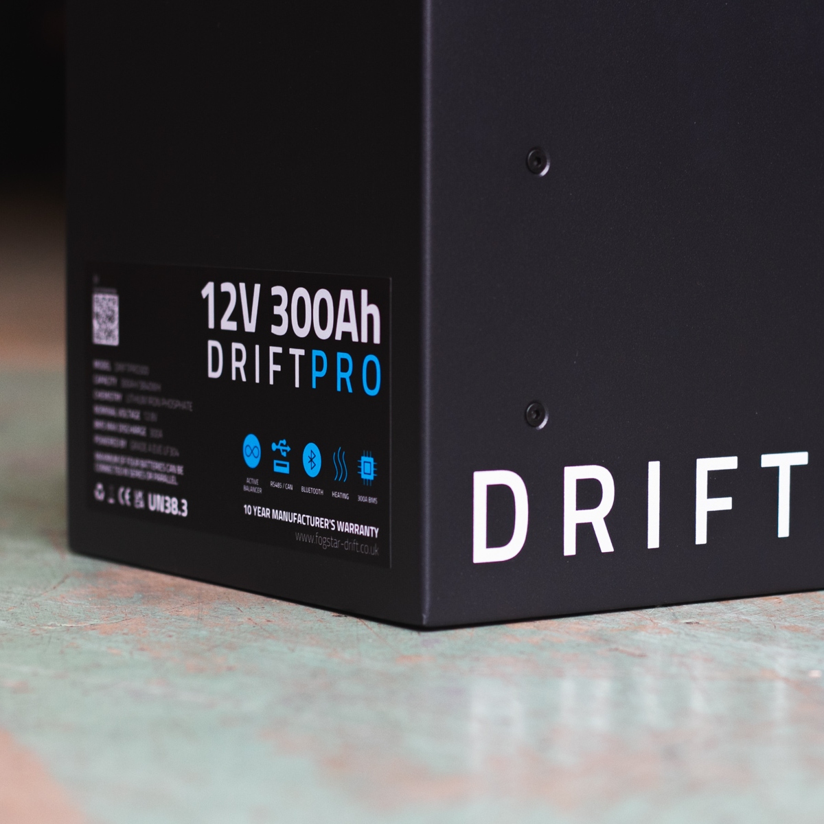Close-up of a black Fogstar Drift PRO 300Ah - 12V lithium leisure battery, showcasing the brand name, specifications, and warranty label.