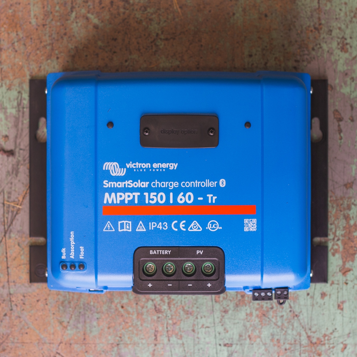 A blue Victron MPPT 150/60 - SmartSolar Charge Controller - Tr rests elegantly on a wooden surface.