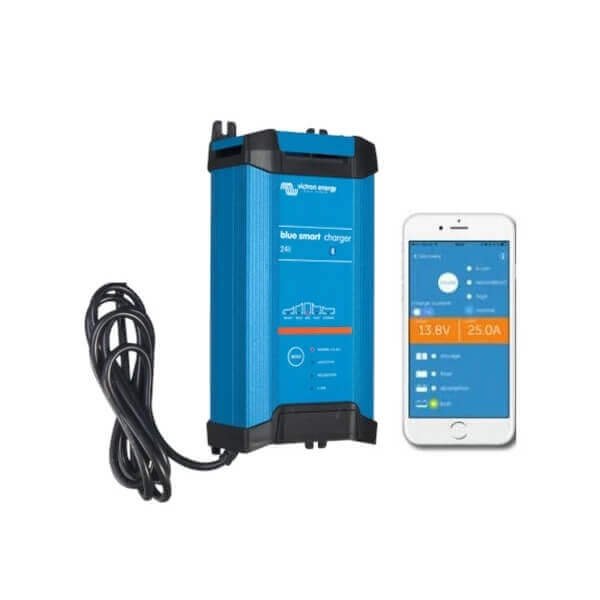 A Victron Battery Charger 24/16 - 24V 16A Indoor (IP22) Blue Smart - 3 Outlets sits beside a smartphone displaying the Victron Battery Charger monitoring app.