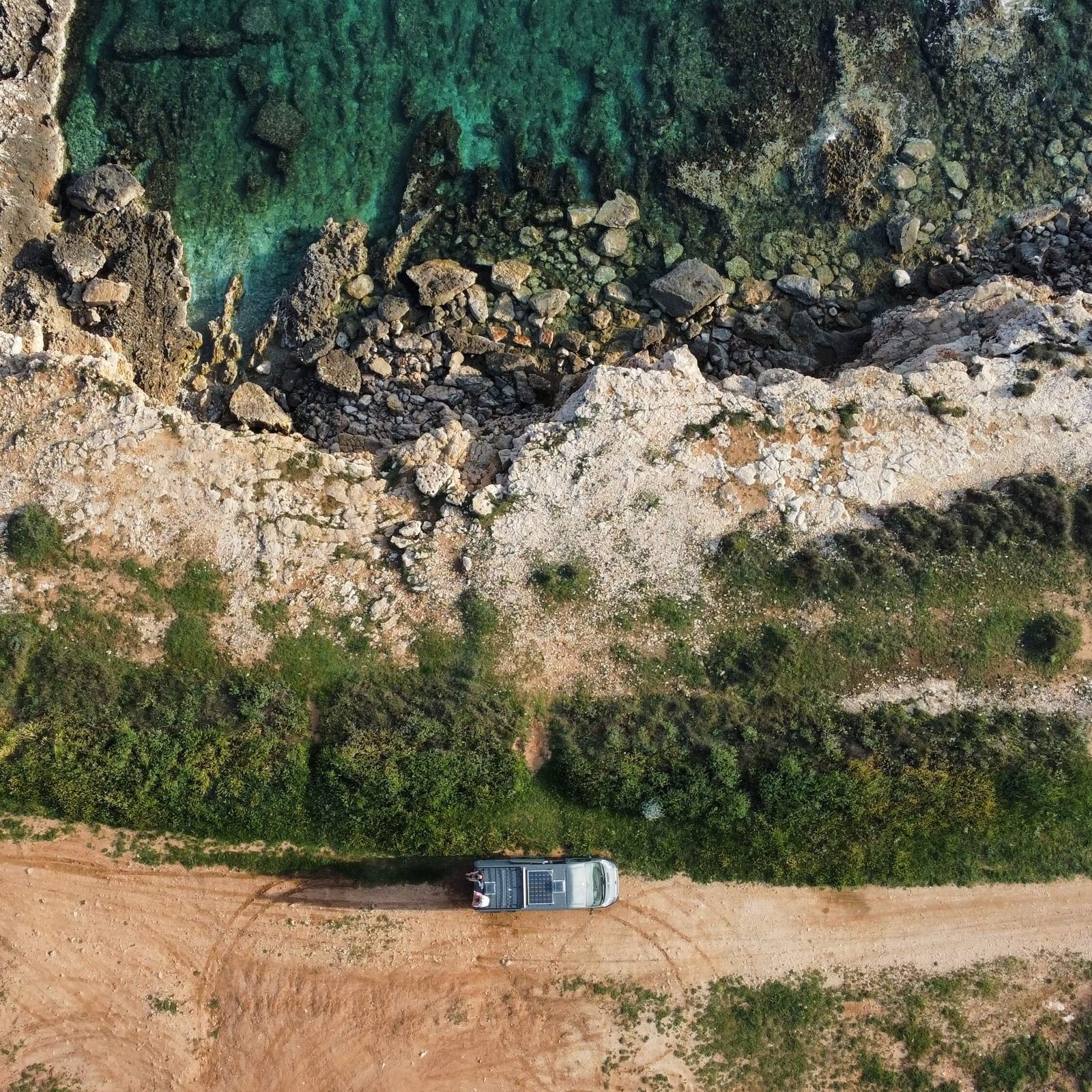 Aerial shot of Becky and Millies van on a cliff by the sea