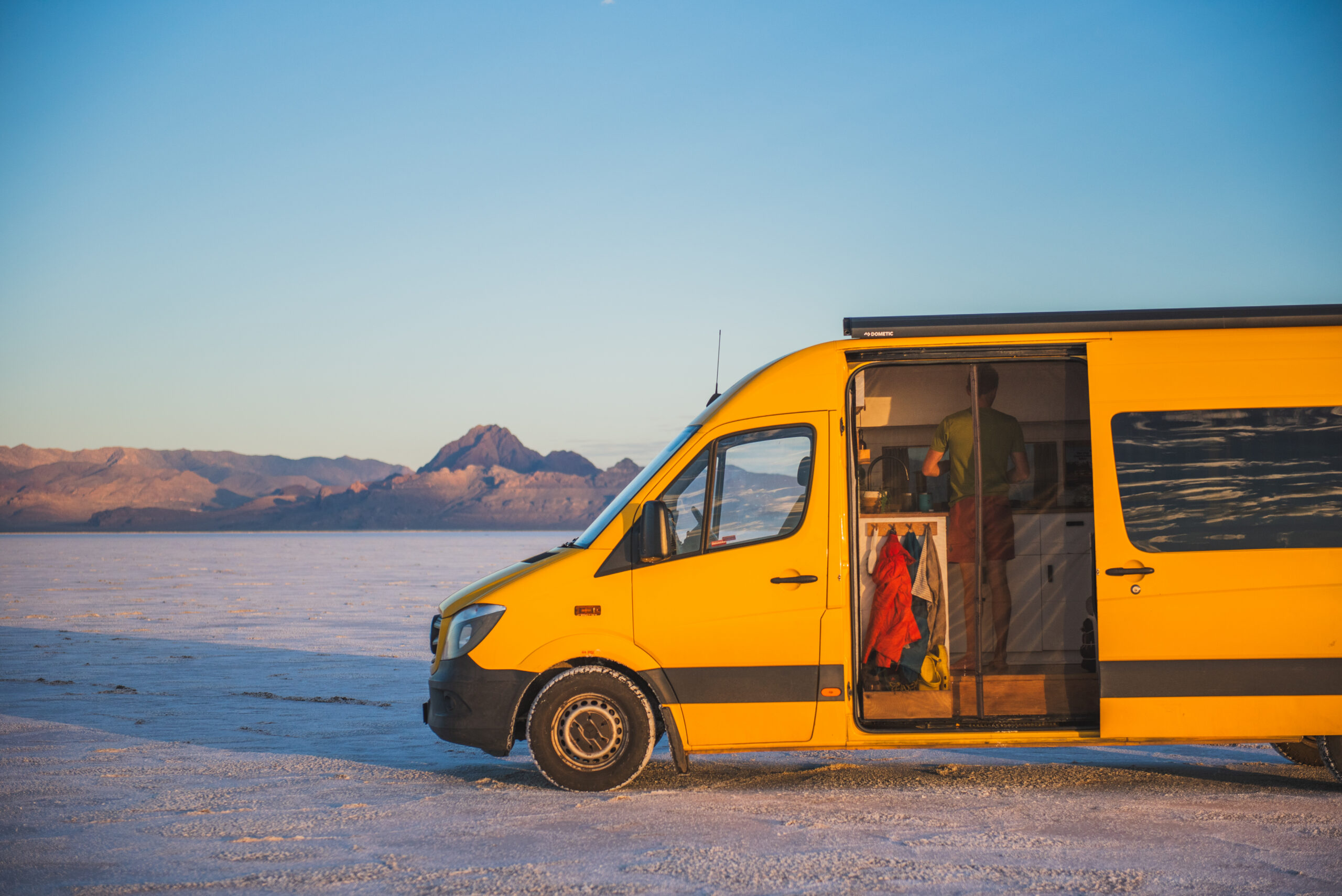 a yellow self converted van parked in the desert