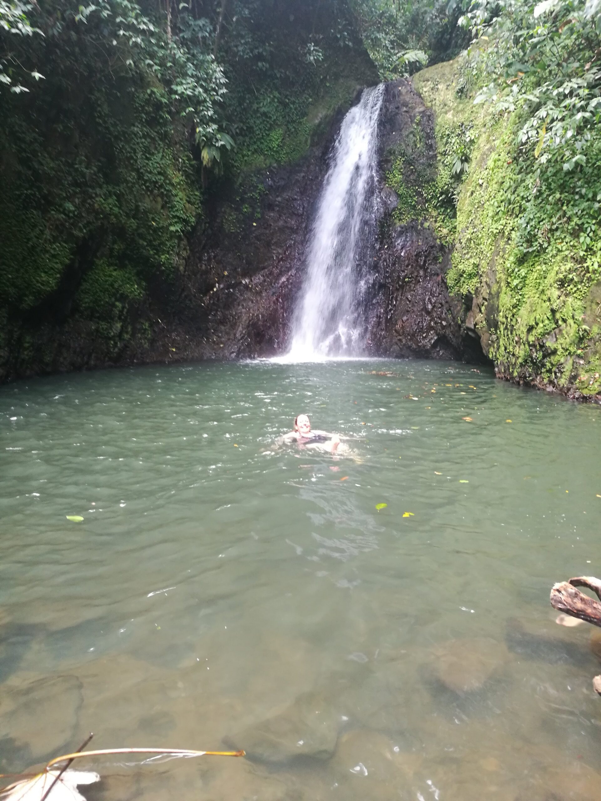 Martina swimming underneath a waterfall in Grenada